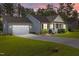 Well-maintained home showcasing an attached two-car garage, a concrete driveway and beautiful landscaping at sunset at 244 Lasswade Ct, Zebulon, NC 27597
