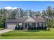 Charming single-story home with a well-manicured lawn, attached garage and inviting front porch at 244 Lasswade Ct, Zebulon, NC 27597