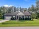 Charming single-story home boasts an attached two-car garage, a manicured lawn and inviting front porch at 244 Lasswade Ct, Zebulon, NC 27597