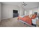 Well-lit main bedroom with neutral tones, carpet, a ceiling fan and an attached bathroom at 244 Lasswade Ct, Zebulon, NC 27597