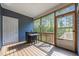 Relaxing screened porch with wicker bar, stools, and views of lush greenery at 244 Lasswade Ct, Zebulon, NC 27597