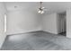 Spacious primary bedroom with three windows for natural light, ceiling fan, and neutral carpeting at 2621 Asher View Ct, Raleigh, NC 27606