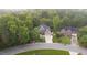 An aerial showcases the home nestled amongst mature trees, a serene setting, and a circular driveway at 3024 Weston Ct, Burlington, NC 27215