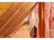 Unfinished attic with exposed beams, pink insulation, and a lightbulb at 3024 Weston Ct, Burlington, NC 27215