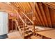 Unfinished attic with pink insulation, wood beams, and pull down stairs at 3024 Weston Ct, Burlington, NC 27215