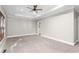 Carpeted bedroom with tray ceilings, fan, and an en-suite bathroom entrance at 3024 Weston Ct, Burlington, NC 27215