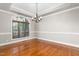 Bright dining room featuring hardwood floors, a decorative chandelier, and a large window with natural light at 3024 Weston Ct, Burlington, NC 27215