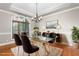 Elegant dining room with glass table, modern chandelier, large window, and beautiful trim at 3024 Weston Ct, Burlington, NC 27215