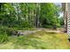 View of a spacious backyard with mature trees, a brick patio, and lawn at 304 Gold Point Dr, Cary, NC 27519