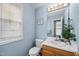 Charming bathroom featuring light blue walls, window, and vanity with decorative plants at 304 Gold Point Dr, Cary, NC 27519