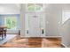 Bright foyer boasts wood floors, large windows, and a playful basketball hoop on the white front door at 304 Gold Point Dr, Cary, NC 27519