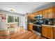 Eat-in kitchen boasts wood cabinets, stainless steel appliances, and a view of the backyard through sliding glass doors at 304 Gold Point Dr, Cary, NC 27519