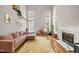 Bright living room with many windows, fireplace, hardwood floors, and comfortable pink sectional sofa at 304 Gold Point Dr, Cary, NC 27519