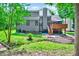 Backyard showcasing a deck, stone landscaping, lush greenery, and a charming home exterior at 306 Roebling Ln, Cary, NC 27513