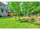 Spacious backyard featuring mature trees, a small bridge, and well-maintained lawn at 306 Roebling Ln, Cary, NC 27513