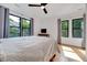 Bright bedroom features a comfortable bed, large windows with leafy views, and hardwood floors at 306 Roebling Ln, Cary, NC 27513