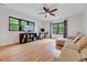 Spacious bedroom with hardwood floors, a ceiling fan, black framed windows, and a cozy seating area at 306 Roebling Ln, Cary, NC 27513