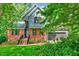 Charming two-story home boasts a brick facade, gray siding, manicured lawn, and lush greenery for added curb appeal at 306 Roebling Ln, Cary, NC 27513