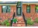 Charming home entrance with brick steps, black railings, a modern glass front door, and lovely floral accents at 306 Roebling Ln, Cary, NC 27513
