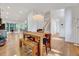Open-concept living area with hardwood floors, a large dining table, and staircase leading to the second floor at 306 Roebling Ln, Cary, NC 27513