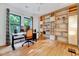 Office space with a built-in bookshelf, large windows, wood floors, and a ceiling fan at 306 Roebling Ln, Cary, NC 27513
