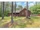 Brick home with backyard trees behind the property and green grass at 3304 Black Stallion Ct, Zebulon, NC 27597
