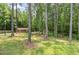 Backyard with shed, mature trees, and open green space, perfect for outdoor activities at 3304 Black Stallion Ct, Zebulon, NC 27597