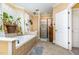 Bright bathroom featuring a tile-surround bathtub with a shower, an open white door, and a glass shower at 3304 Black Stallion Ct, Zebulon, NC 27597