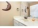 Bathroom featuring a modern sink and vanity, moon decor, and a well-lit mirror, creating a cozy space at 3304 Black Stallion Ct, Zebulon, NC 27597