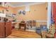 Bedroom featuring wood floors, a zebra patterned chair, desk and shelves with art and assorted items at 3304 Black Stallion Ct, Zebulon, NC 27597