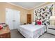 Bedroom with neutral-colored walls, double doors, carpet, and window with decorative curtains at 3304 Black Stallion Ct, Zebulon, NC 27597