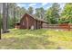 Exterior backyard showing a brick home with a fenced yard and lush landscaping at 3304 Black Stallion Ct, Zebulon, NC 27597