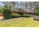 Beautiful brick house surrounded by mature trees and lush landscaping with a side porch at 3304 Black Stallion Ct, Zebulon, NC 27597