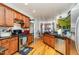 Well-lit kitchen with stainless steel appliances, wood cabinets, and hardwood floors offers ample counter space at 3304 Black Stallion Ct, Zebulon, NC 27597