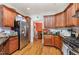 Spacious kitchen with stainless steel refrigerator, wood cabinets and black countertops offers ample storage space at 3304 Black Stallion Ct, Zebulon, NC 27597