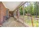 Covered porch featuring wood floors, screening and view of wooded backyard at 3304 Black Stallion Ct, Zebulon, NC 27597