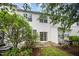 Back exterior with patio and sliding glass door, surrounded by verdant greenery and landscaping at 3519 Sugar Tree Pl, Durham, NC 27713