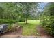 Manicured backyard with lush green grass and mature landscaping, offering a serene outdoor space at 3519 Sugar Tree Pl, Durham, NC 27713