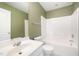 Bathroom featuring shower-tub combo, green walls and white fixtures at 3519 Sugar Tree Pl, Durham, NC 27713