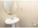 Pedestal sink in a bathroom with an oval mirror and neutral decor at 3519 Sugar Tree Pl, Durham, NC 27713