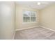 Bright bedroom with neutral carpet features a ceiling fan and a large window at 3519 Sugar Tree Pl, Durham, NC 27713