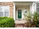 Close-up of the front entryway featuring an inviting green door and manicured landscaping at 3519 Sugar Tree Pl, Durham, NC 27713