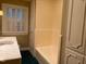 Bathroom with window, storage and bath tub with cream tile surround at 3604 Woodlawn Rd, Rocky Mount, NC 27804