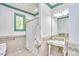 A tiled bathroom featuring mosaic trim, a shower with curtain, and a pedestal sink at 3605 Laurel Creek Way, Durham, NC 27712