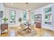 Bright dining room featuring a glass table, four chairs, hardwood floors, and three windows for ample natural light at 3605 Laurel Creek Way, Durham, NC 27712