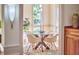 Elegant dining room boasting a glass table, modern chairs, and ample natural light from the surrounding windows at 3605 Laurel Creek Way, Durham, NC 27712