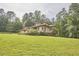 Low angle of a stylish single-story residence with beautiful landscaping, and a sprawling green lawn at 3605 Laurel Creek Way, Durham, NC 27712