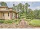 A brick walkway leads to a home featuring manicured landscaping and set against a backdrop of towering trees at 3605 Laurel Creek Way, Durham, NC 27712