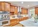 Well-lit kitchen featuring wood cabinets, stainless steel appliances, and white countertops at 3605 Laurel Creek Way, Durham, NC 27712