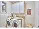 Well-lit laundry room with white cabinets, washer, and dryer at 3605 Laurel Creek Way, Durham, NC 27712